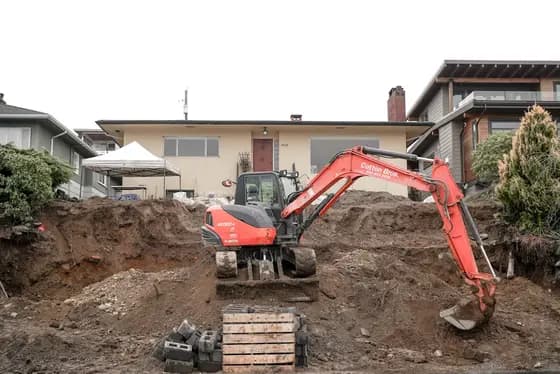 An excavator digging foundation trenches on a cleared stand