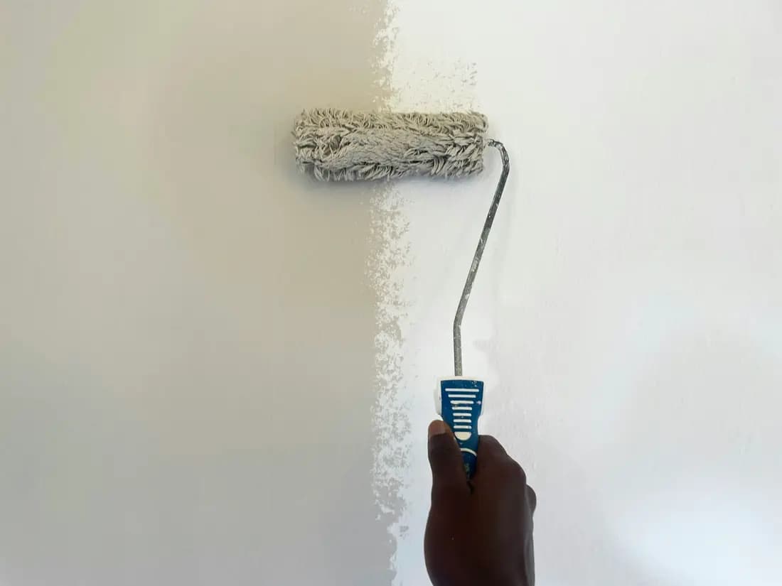 A paint roller being run over a wall