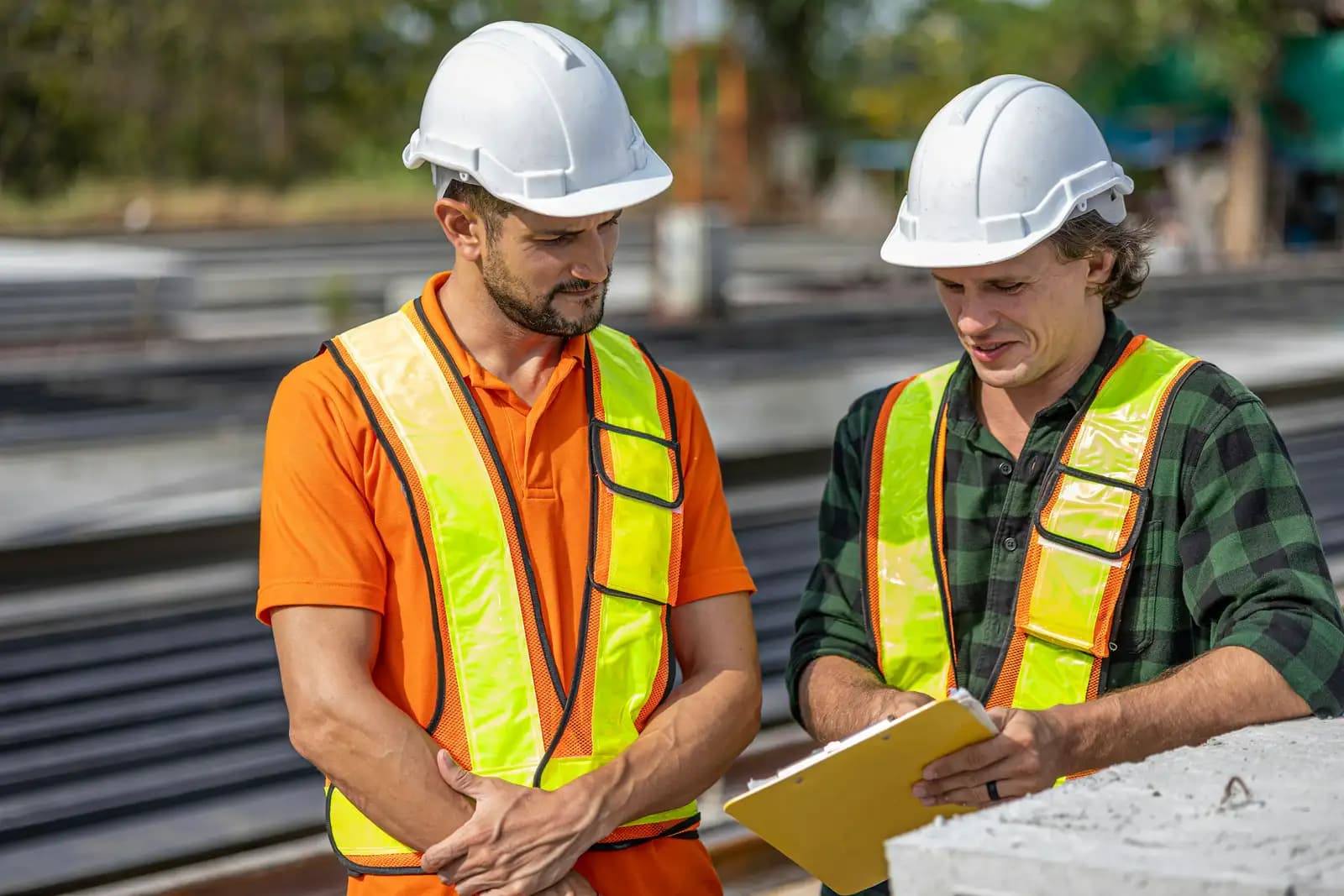 Two site workers talking over a clipboard